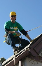 Brian with Denver Gutter Cleaning roped off on a roof